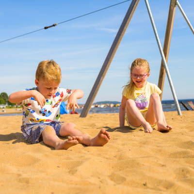 Två barn leker i sanden på Byske Havsbad