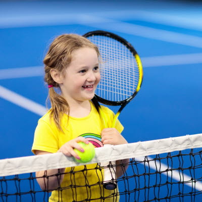 Flicka håller i ett tennisracket