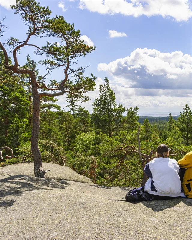 Två personer sitter på berg och tittar på utsikten